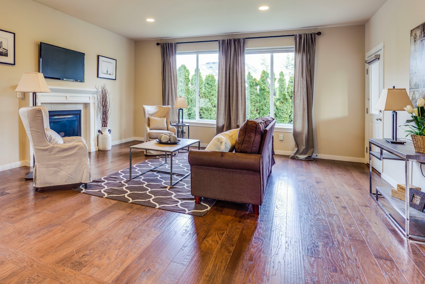 Modern living room with hardwood floors and a comfortable seating arrangement.