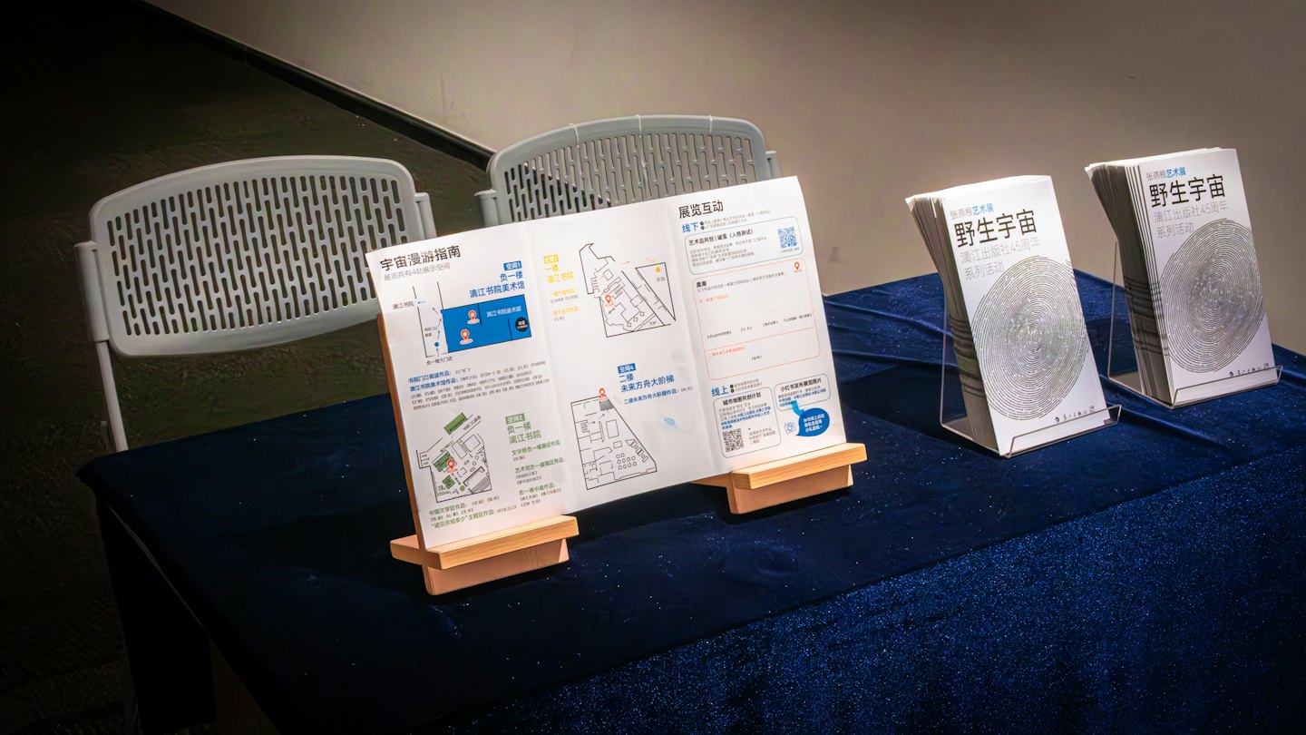 Brochures and booklets on stands displayed on a blue table.
