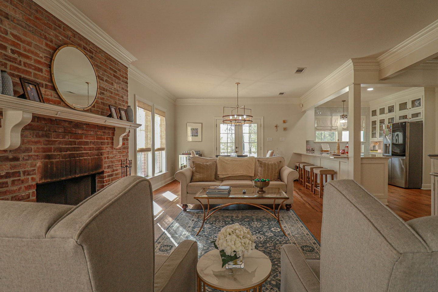 Spacious living room featuring a red brick fireplace and seating area.